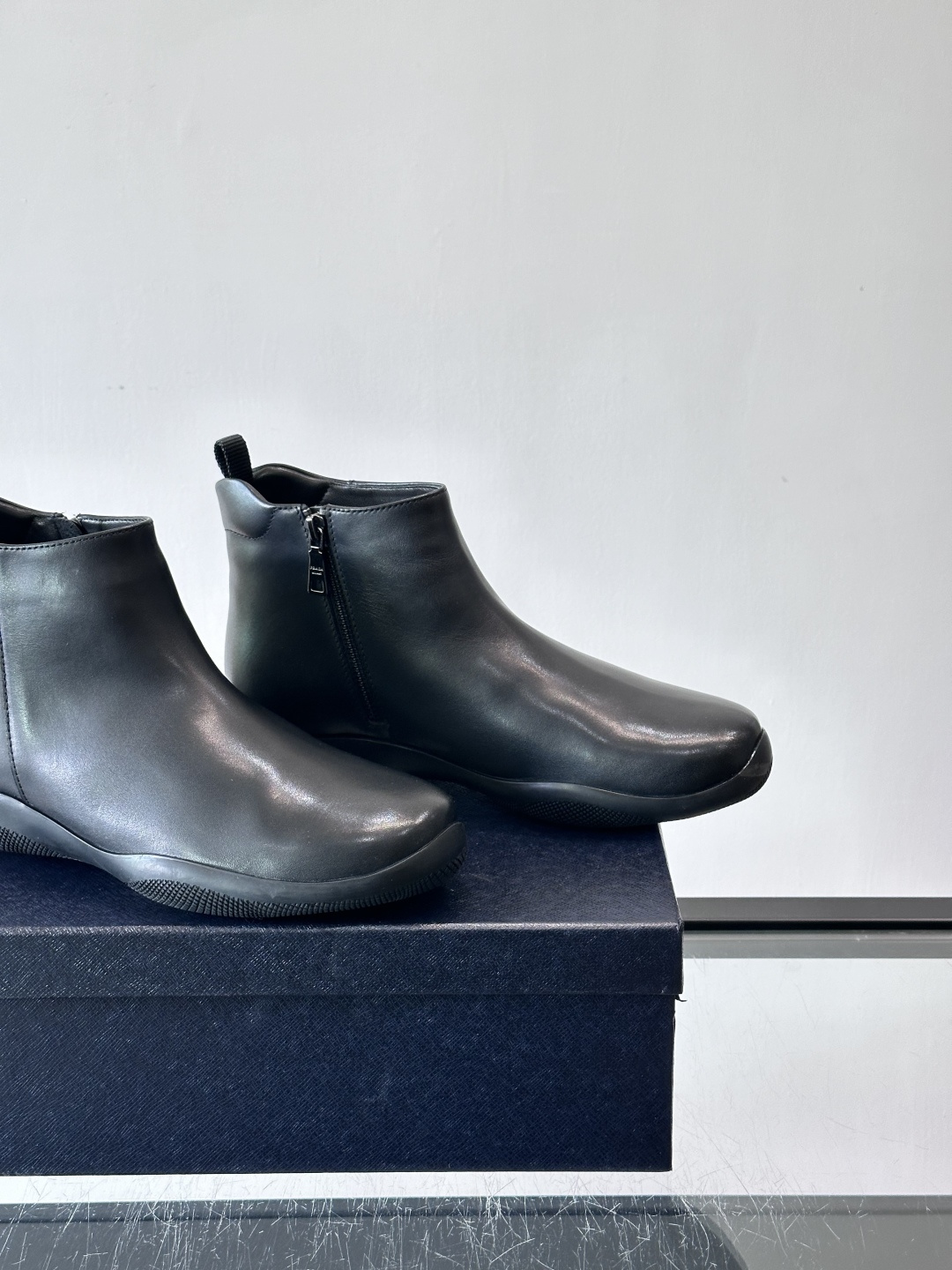 Prada男士黑色短靴，采用头层牛皮，质感细腻耐用。圆头+高帮拉链设计，简约复古，日常通勤或休闲都能轻松