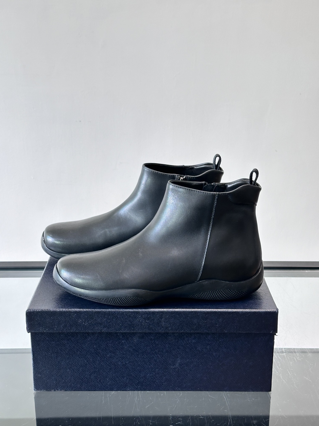 Prada男士黑色短靴，采用头层牛皮，质感细腻耐用。圆头+高帮拉链设计，简约复古，日常通勤或休闲都能轻松