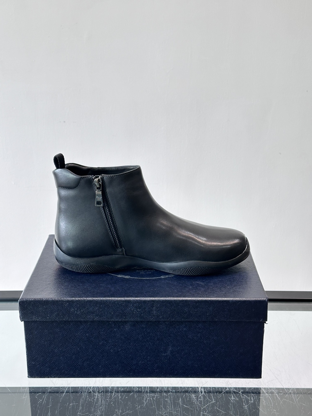 Prada男士黑色短靴，采用头层牛皮，质感细腻耐用。圆头+高帮拉链设计，简约复古，日常通勤或休闲都能轻松