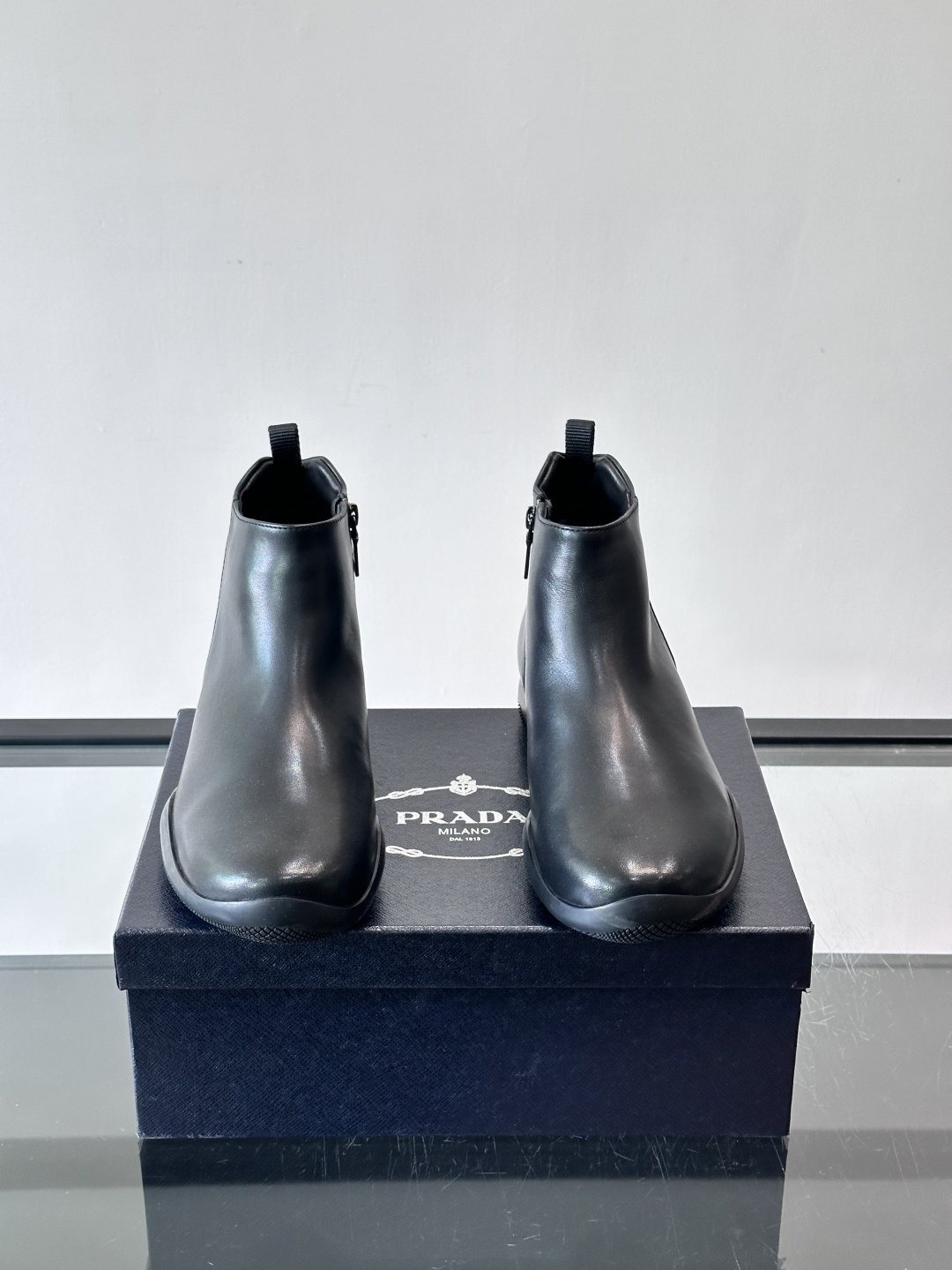 Prada男士黑色短靴，采用头层牛皮，质感细腻耐用。圆头+高帮拉链设计，简约复古，日常通勤或休闲都能轻松