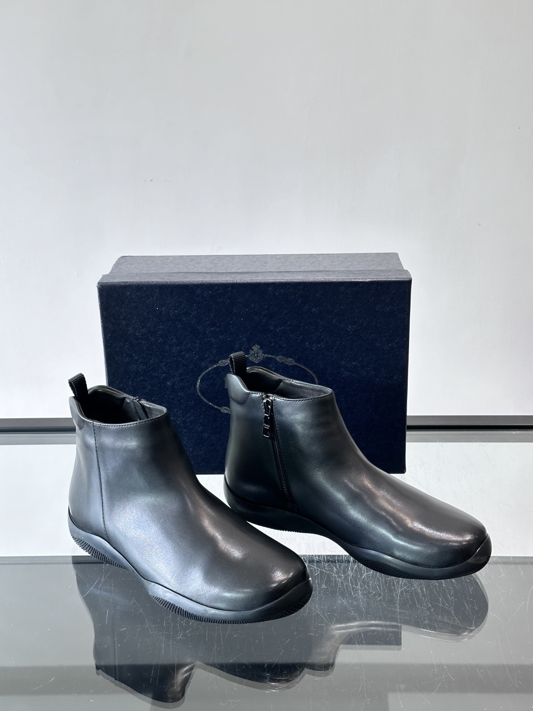 Prada男士黑色短靴，采用头层牛皮，质感细腻耐用。圆头+高帮拉链设计，简约复古，日常通勤或休闲都能轻松