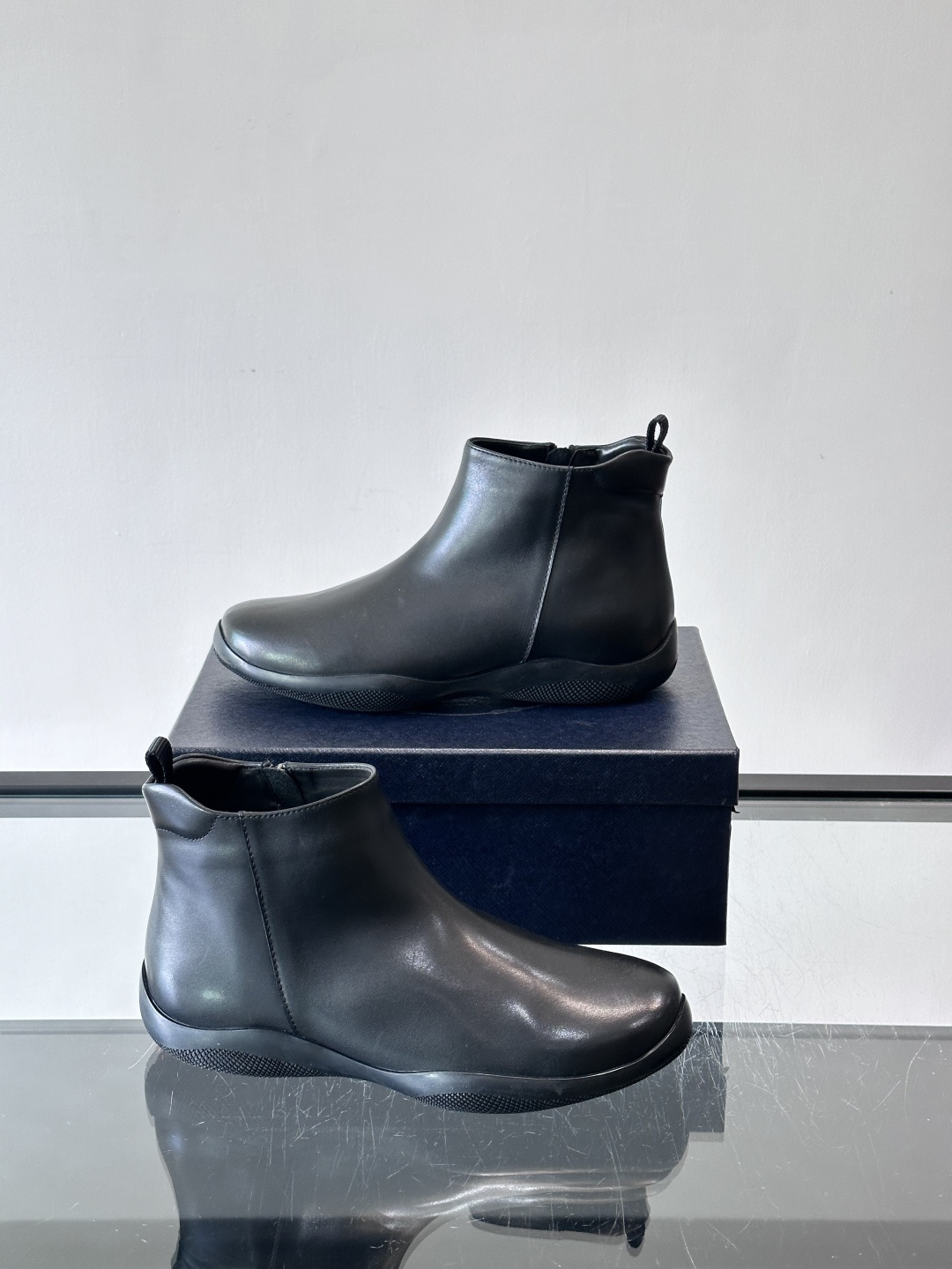 Prada男士黑色短靴，采用头层牛皮，质感细腻耐用。圆头+高帮拉链设计，简约复古，日常通勤或休闲都能轻松