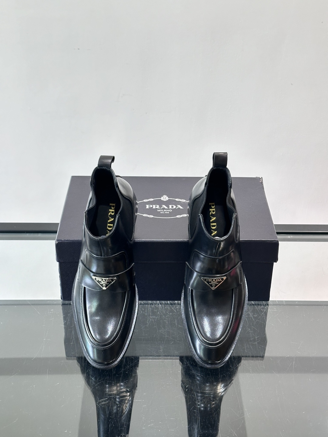 Prada男士切尔西靴，选用高品质真皮，漆皮质感超有光泽感 。方头设计+侧边松紧带，穿脱方便又贴合脚型。