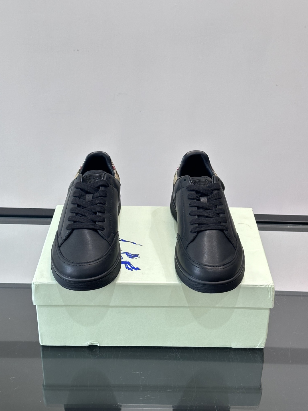 Burberry经典男士板鞋，采用小牛皮材质，鞋面光滑细腻，搭配标志性格纹织物后跟，英伦风满满。橡胶鞋底