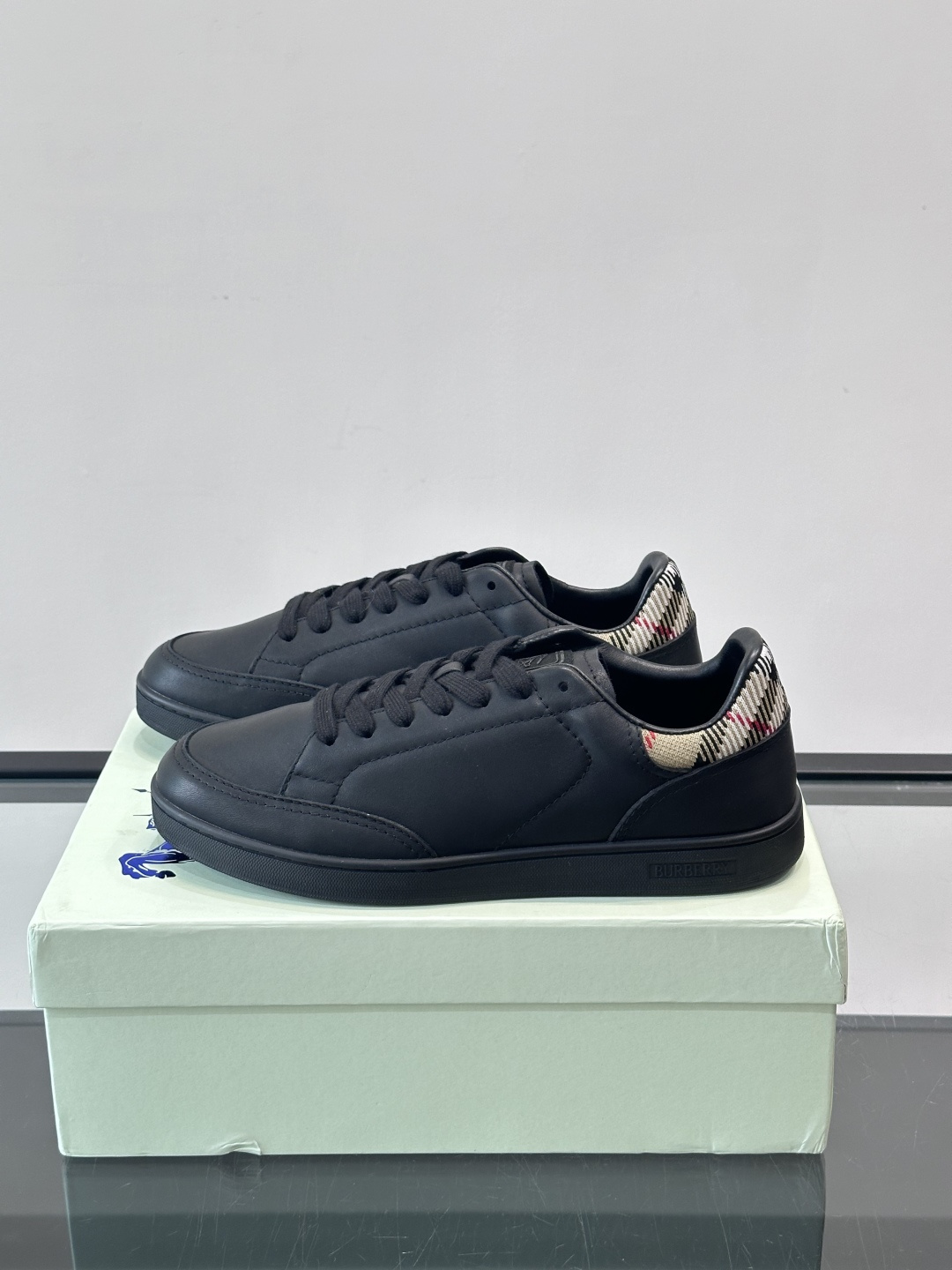 Burberry经典男士板鞋，采用小牛皮材质，鞋面光滑细腻，搭配标志性格纹织物后跟，英伦风满满。橡胶鞋底