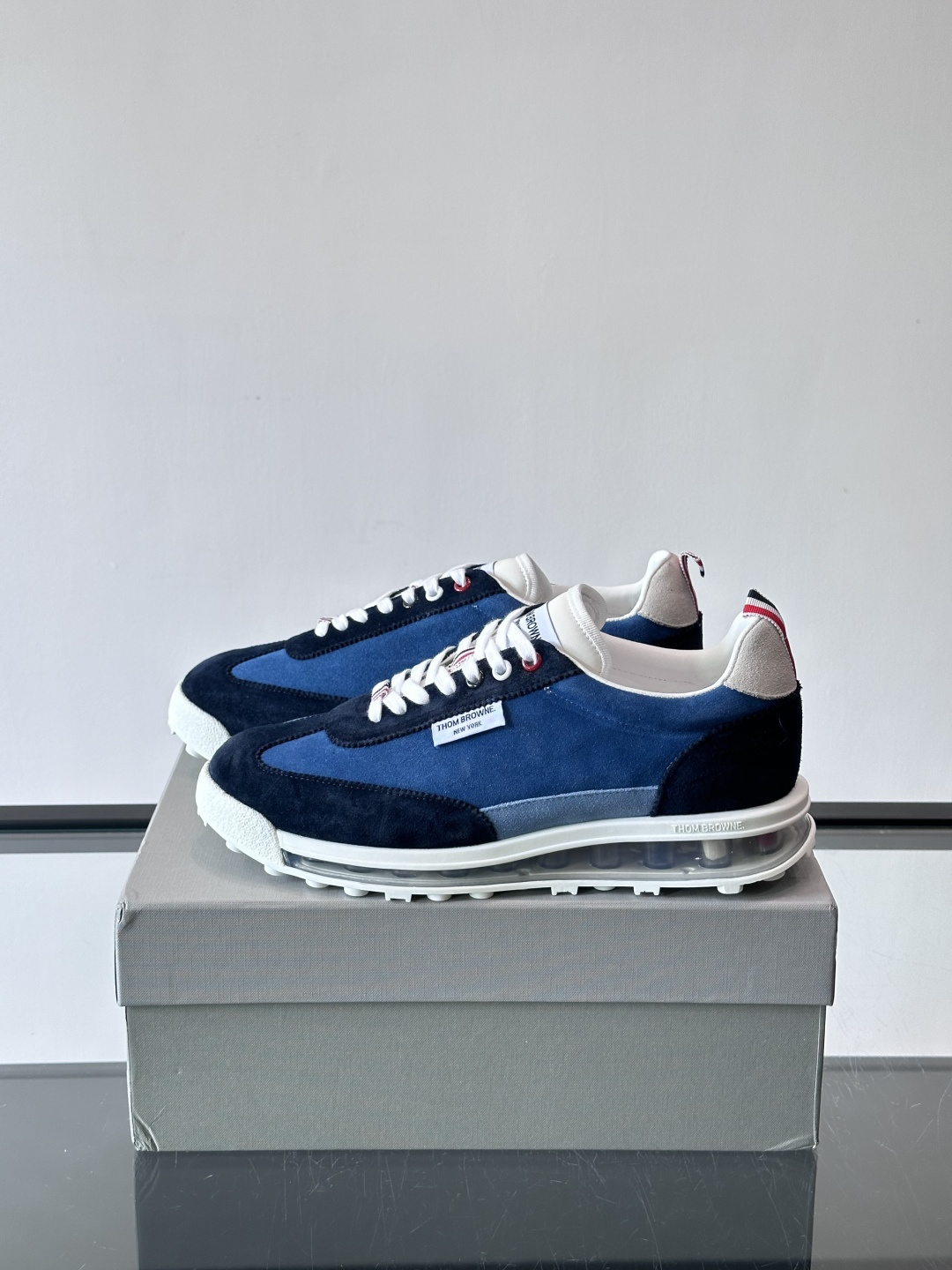 Thom Browne男士气垫休闲鞋，麂皮+牛皮拼接，质感细腻又透气。标志性红白蓝鞋带，辨识度超高。透明