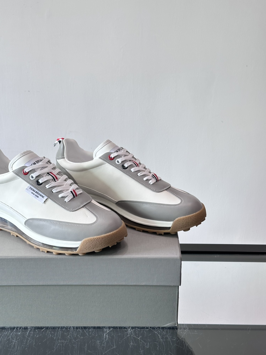 Thom Browne男士气垫休闲鞋，麂皮+牛皮拼接，质感细腻又透气。标志性红白蓝鞋带，辨识度超高。透明