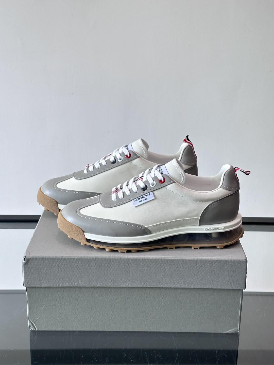 Thom Browne男士气垫休闲鞋，麂皮+牛皮拼接，质感细腻又透气。标志性红白蓝鞋带，辨识度超高。透明