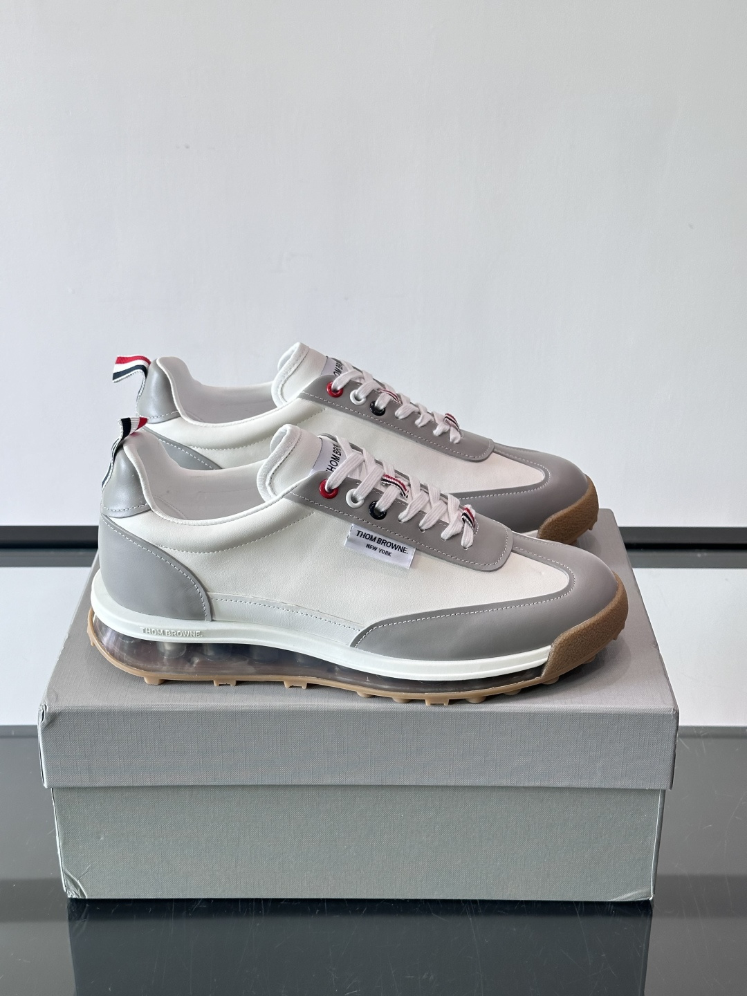 Thom Browne男士气垫休闲鞋，麂皮+牛皮拼接，质感细腻又透气。标志性红白蓝鞋带，辨识度超高。透明