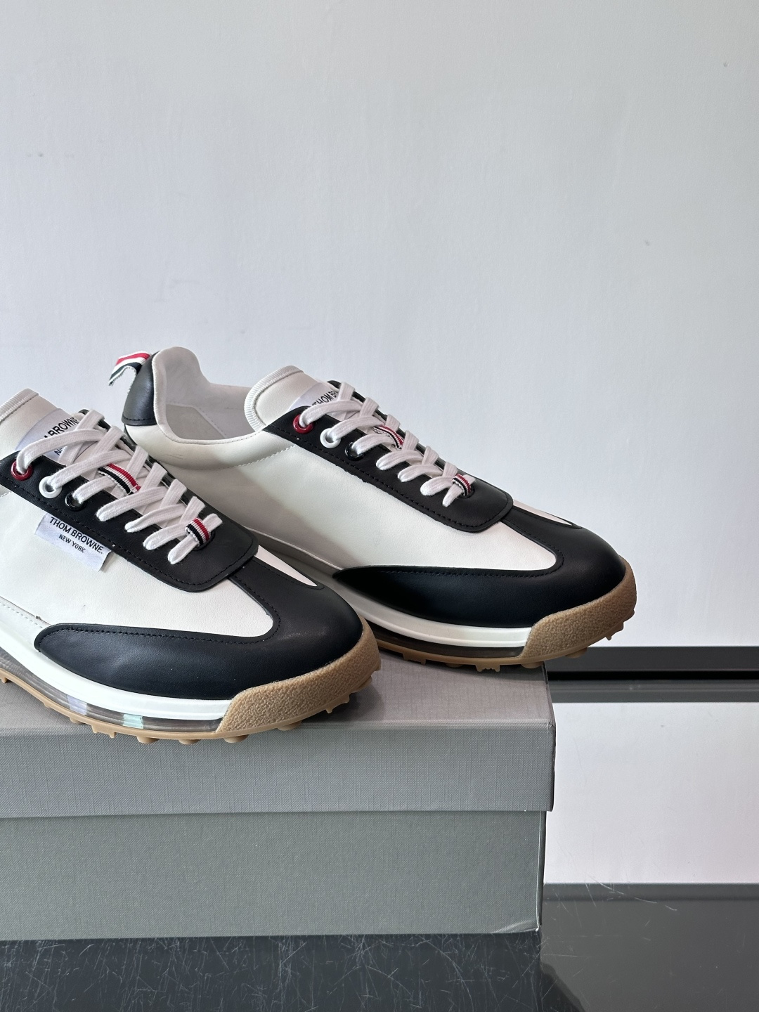 Thom Browne男士气垫休闲鞋，麂皮+牛皮拼接，质感细腻又透气。标志性红白蓝鞋带，辨识度超高。透明