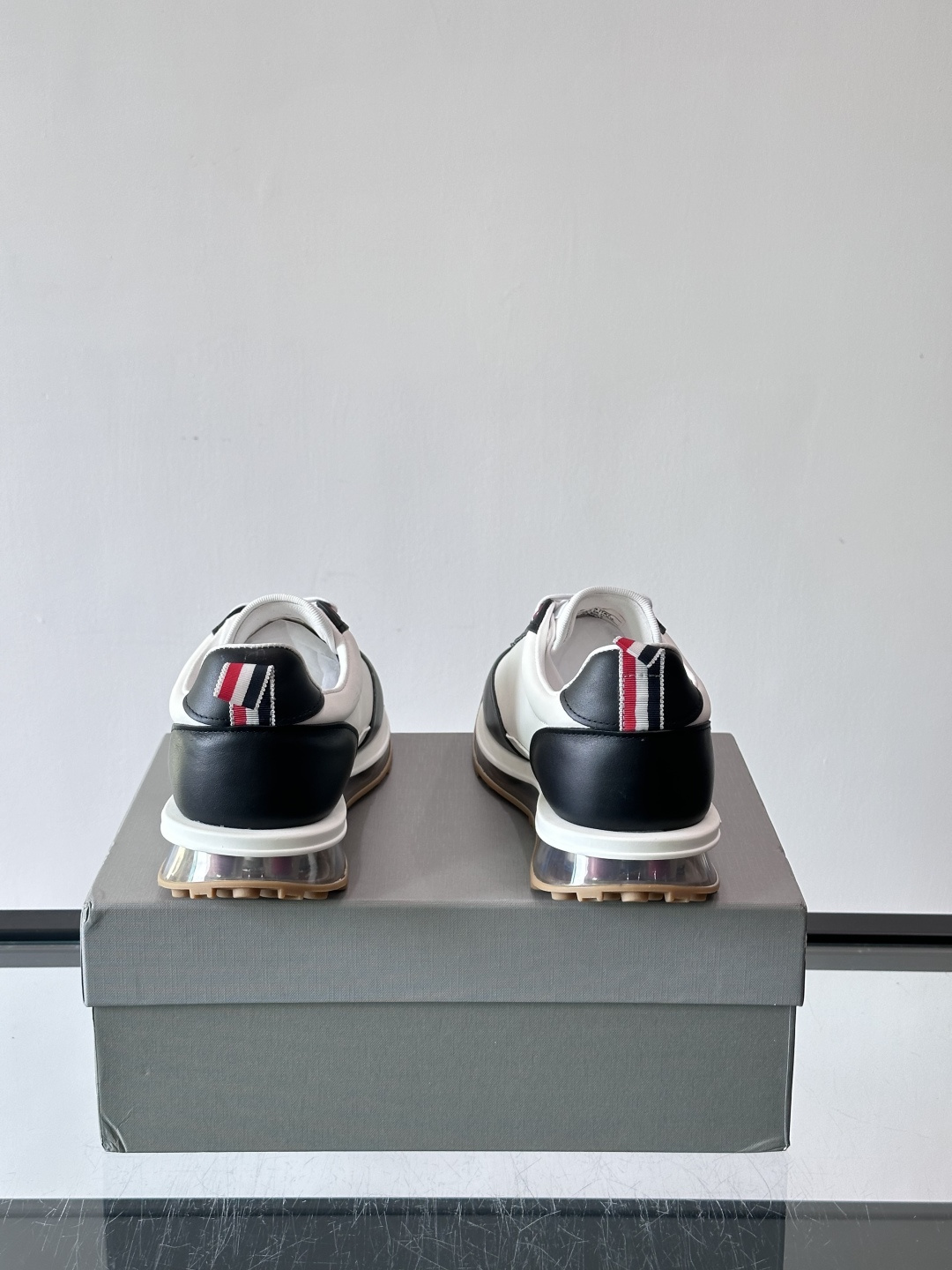 Thom Browne男士气垫休闲鞋，麂皮+牛皮拼接，质感细腻又透气。标志性红白蓝鞋带，辨识度超高。透明