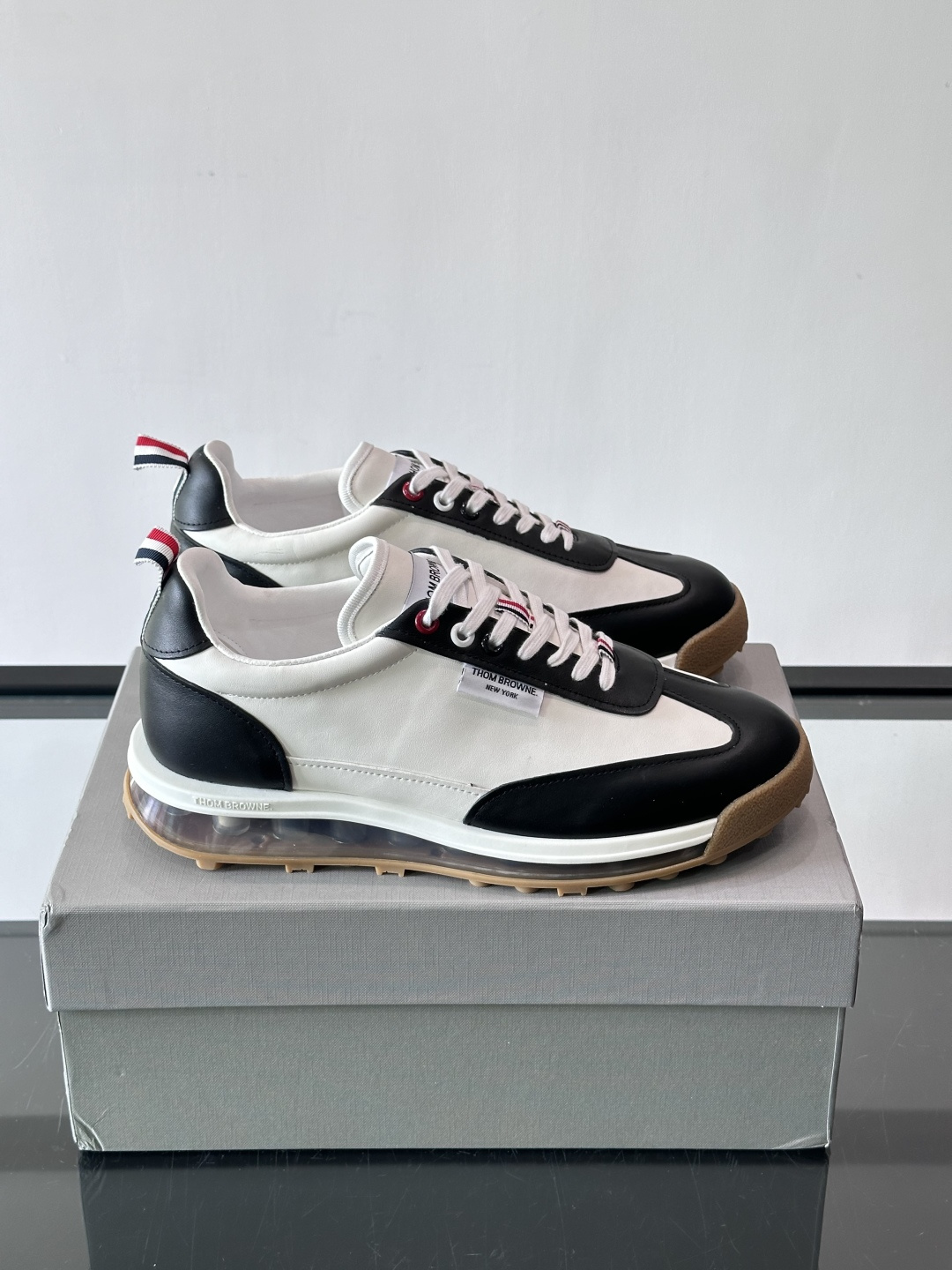 Thom Browne男士气垫休闲鞋，麂皮+牛皮拼接，质感细腻又透气。标志性红白蓝鞋带，辨识度超高。透明
