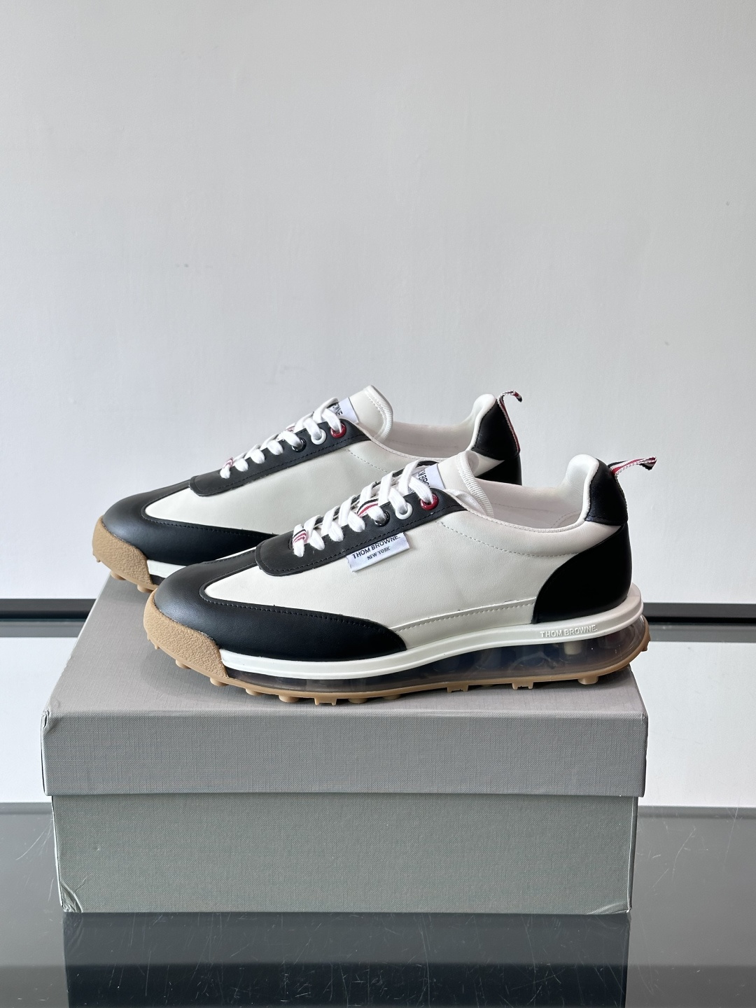 Thom Browne男士气垫休闲鞋，麂皮+牛皮拼接，质感细腻又透气。标志性红白蓝鞋带，辨识度超高。透明