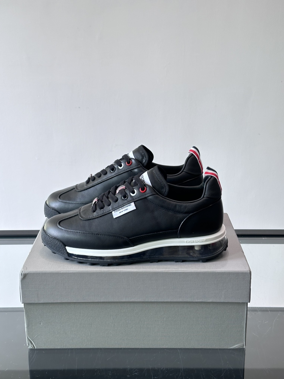 Thom Browne男士气垫休闲鞋，麂皮+牛皮拼接，质感细腻又透气。标志性红白蓝鞋带，辨识度超高。透明