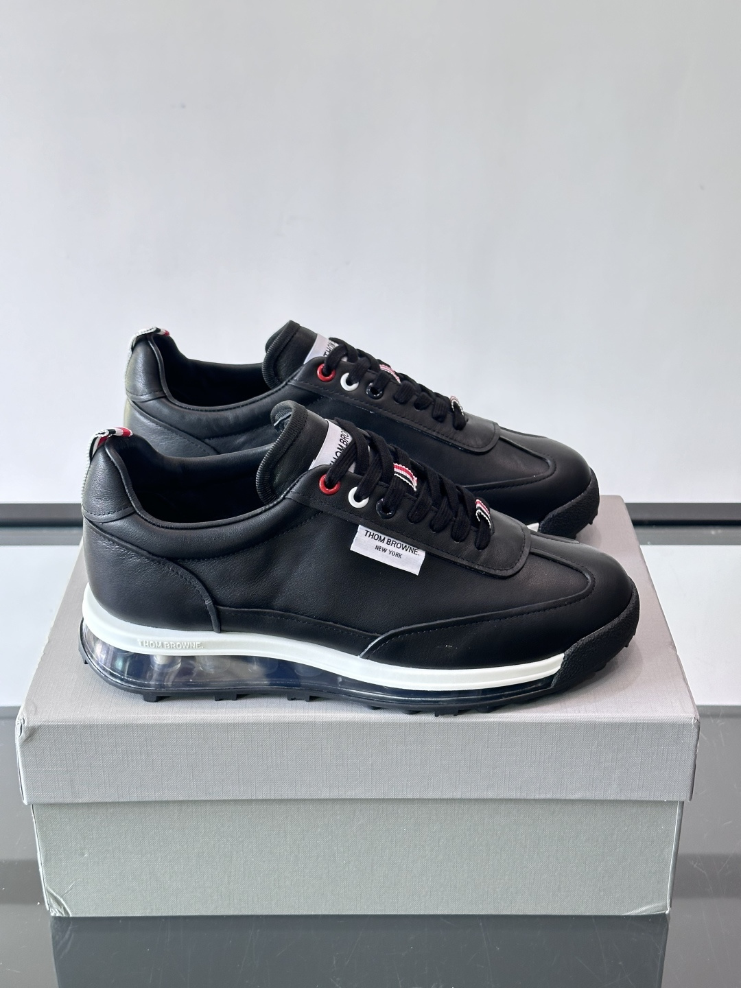 Thom Browne男士气垫休闲鞋，麂皮+牛皮拼接，质感细腻又透气。标志性红白蓝鞋带，辨识度超高。透明