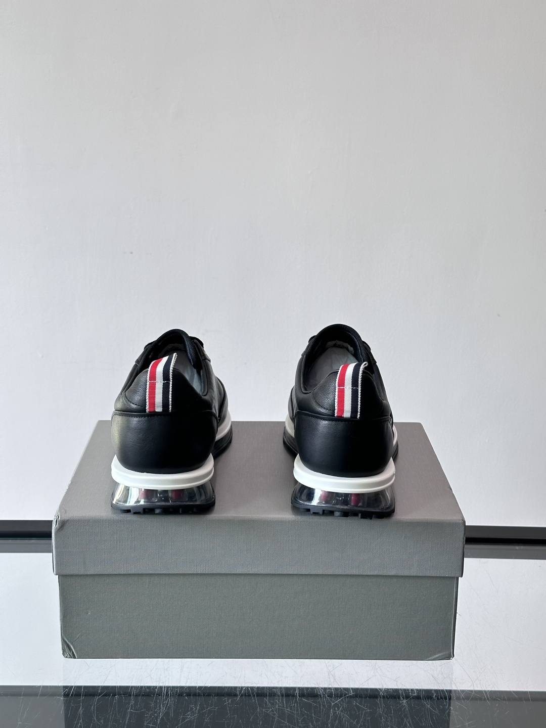 Thom Browne男士气垫休闲鞋，麂皮+牛皮拼接，质感细腻又透气。标志性红白蓝鞋带，辨识度超高。透明