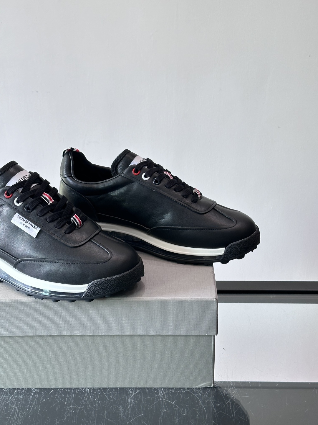 Thom Browne男士气垫休闲鞋，麂皮+牛皮拼接，质感细腻又透气。标志性红白蓝鞋带，辨识度超高。透明