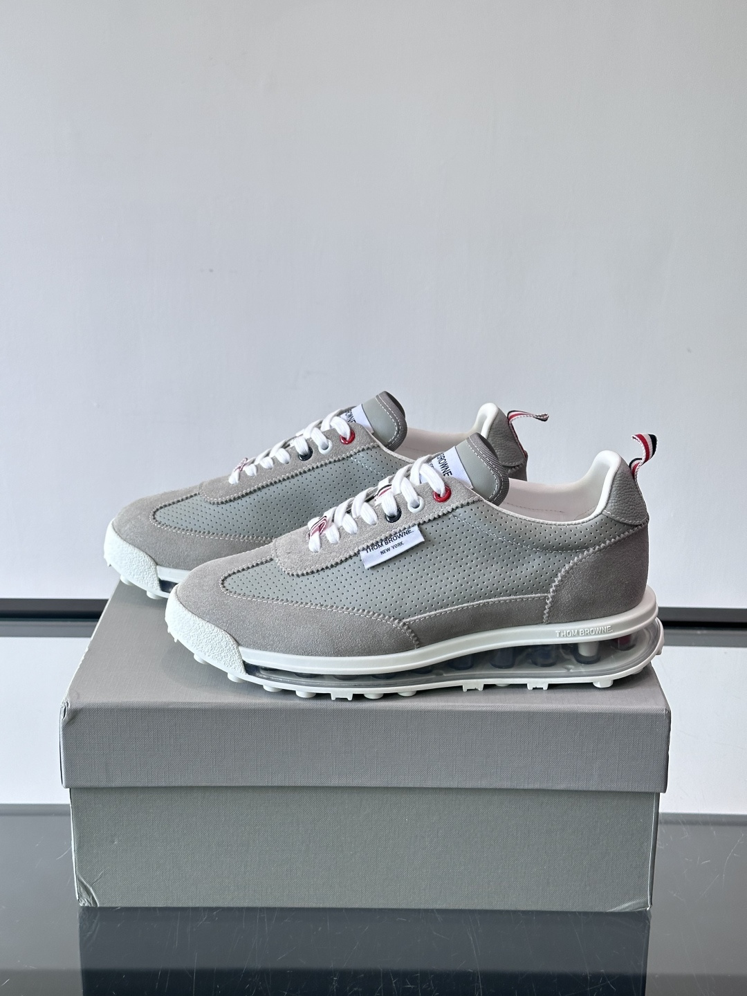 Thom Browne男士气垫休闲鞋，麂皮+牛皮拼接，质感细腻又透气。标志性红白蓝鞋带，辨识度超高。透明