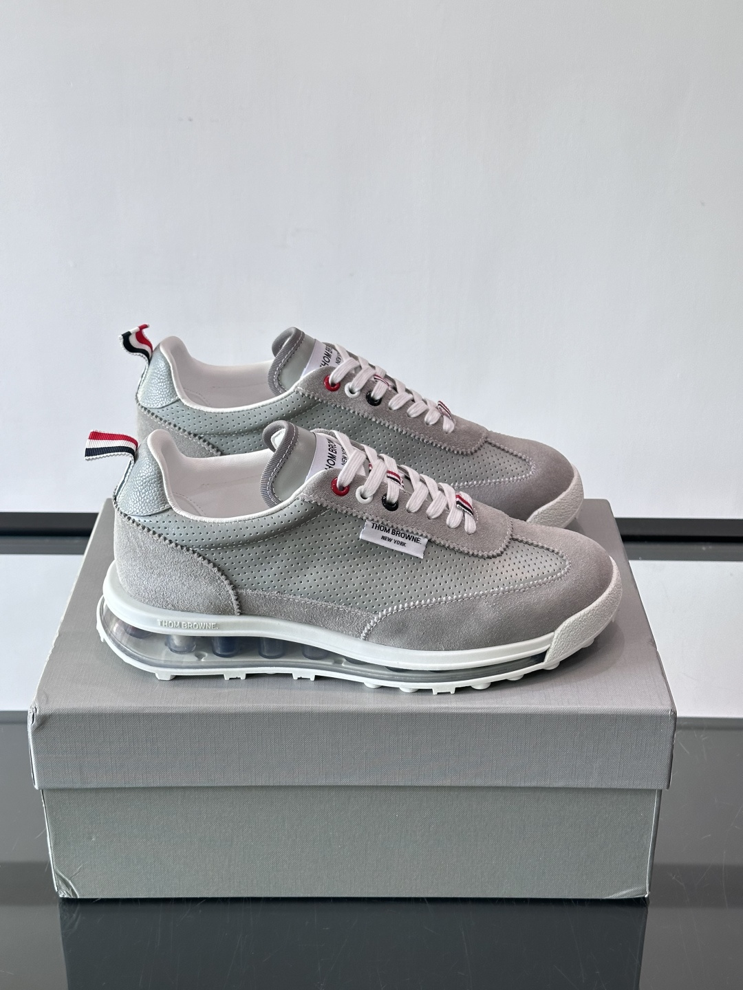 Thom Browne男士气垫休闲鞋，麂皮+牛皮拼接，质感细腻又透气。标志性红白蓝鞋带，辨识度超高。透明