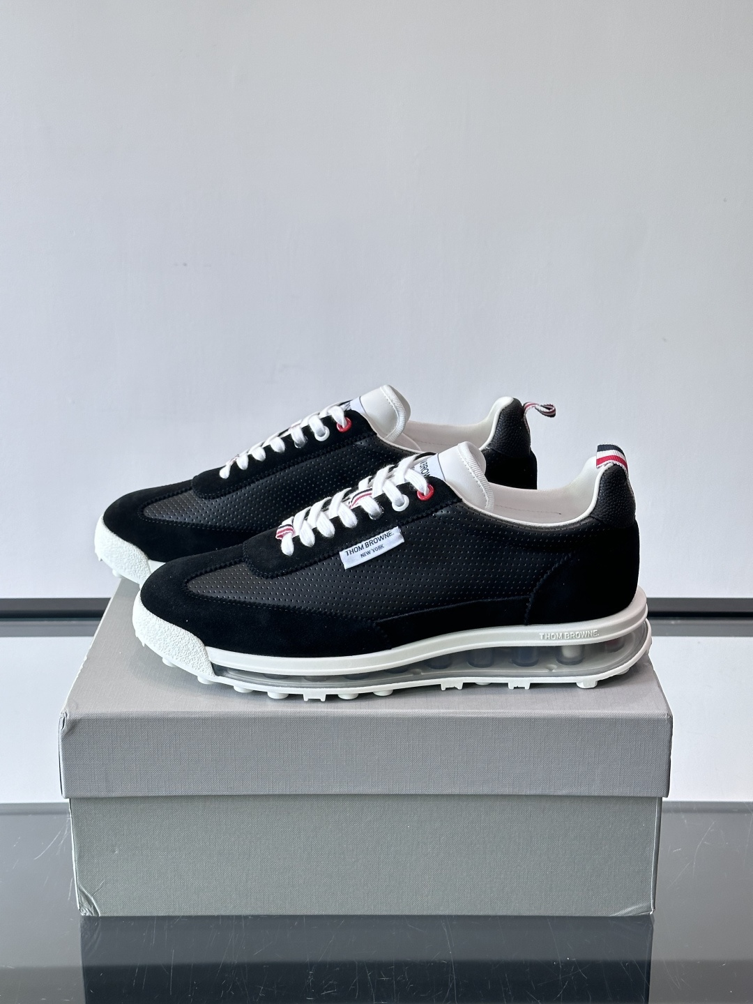 Thom Browne男士气垫休闲鞋，麂皮+牛皮拼接，质感细腻又透气。标志性红白蓝鞋带，辨识度超高。透明