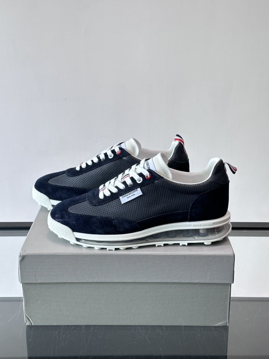 Thom Browne男士气垫休闲鞋，麂皮+牛皮拼接，质感细腻又透气。标志性红白蓝鞋带，辨识度超高。透明