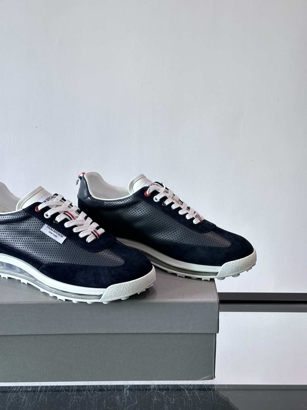 Thom Browne男士气垫休闲鞋，麂皮+牛皮拼接，质感细腻又透气。标志性红白蓝鞋带，辨识度超高。透明
