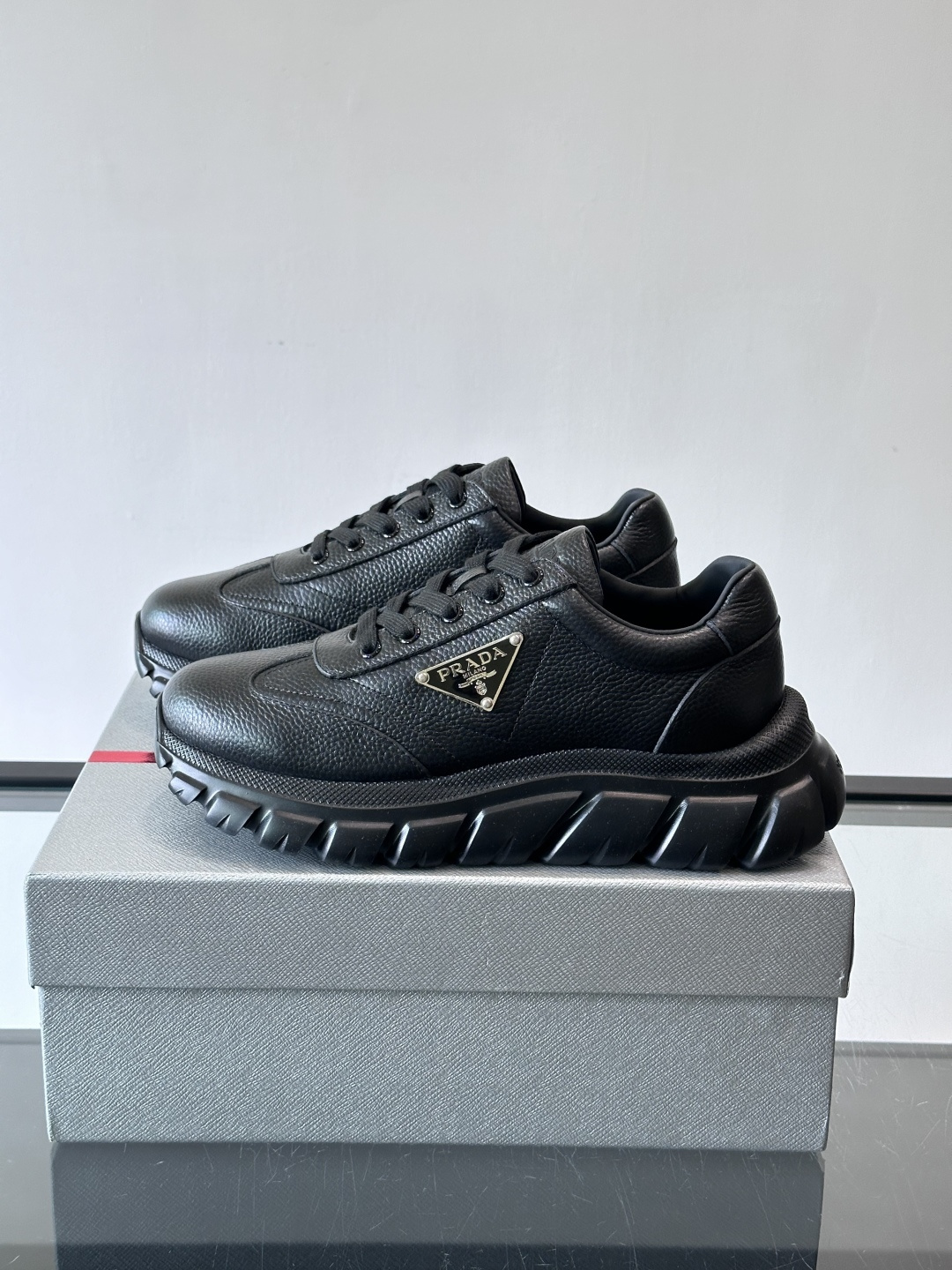 Prada男士休闲运动鞋，采用优质牛皮，鞋面柔软细腻，搭配经典三角金属Logo，品牌辨识度超高✨。厚底设