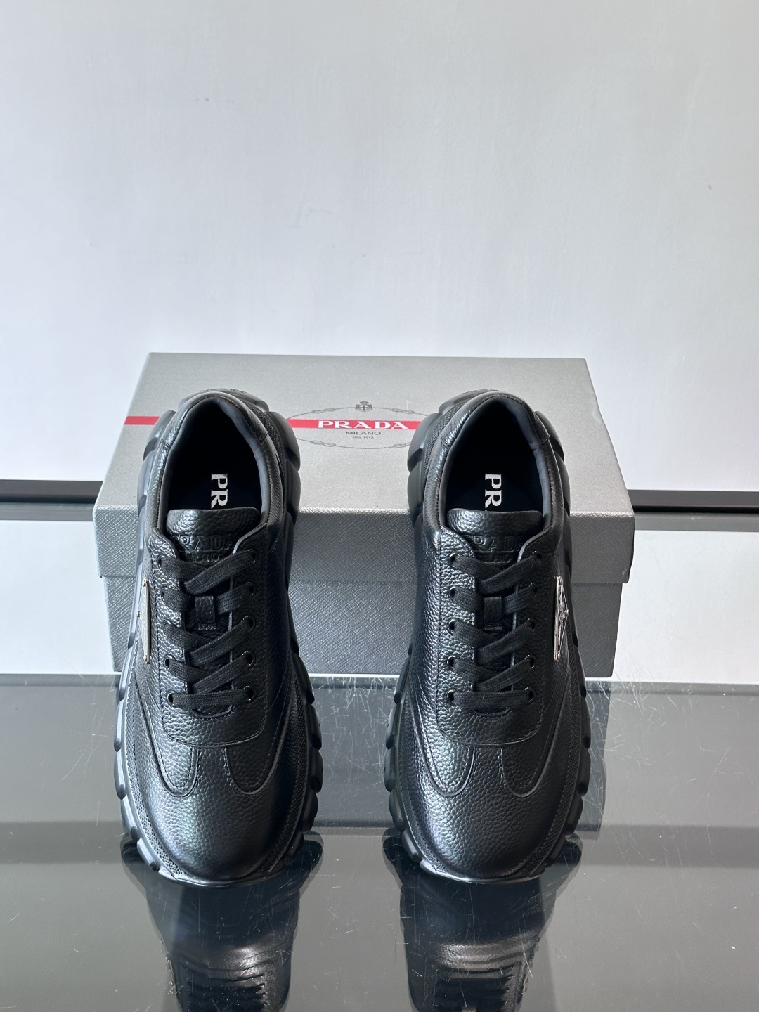Prada男士休闲运动鞋，采用优质牛皮，鞋面柔软细腻，搭配经典三角金属Logo，品牌辨识度超高✨。厚底设