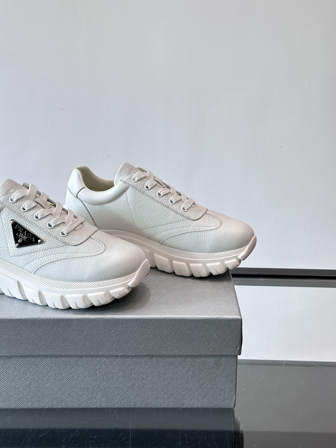 Prada男士休闲运动鞋，采用优质牛皮，鞋面柔软细腻，搭配经典三角金属Logo，品牌辨识度超高✨。厚底设