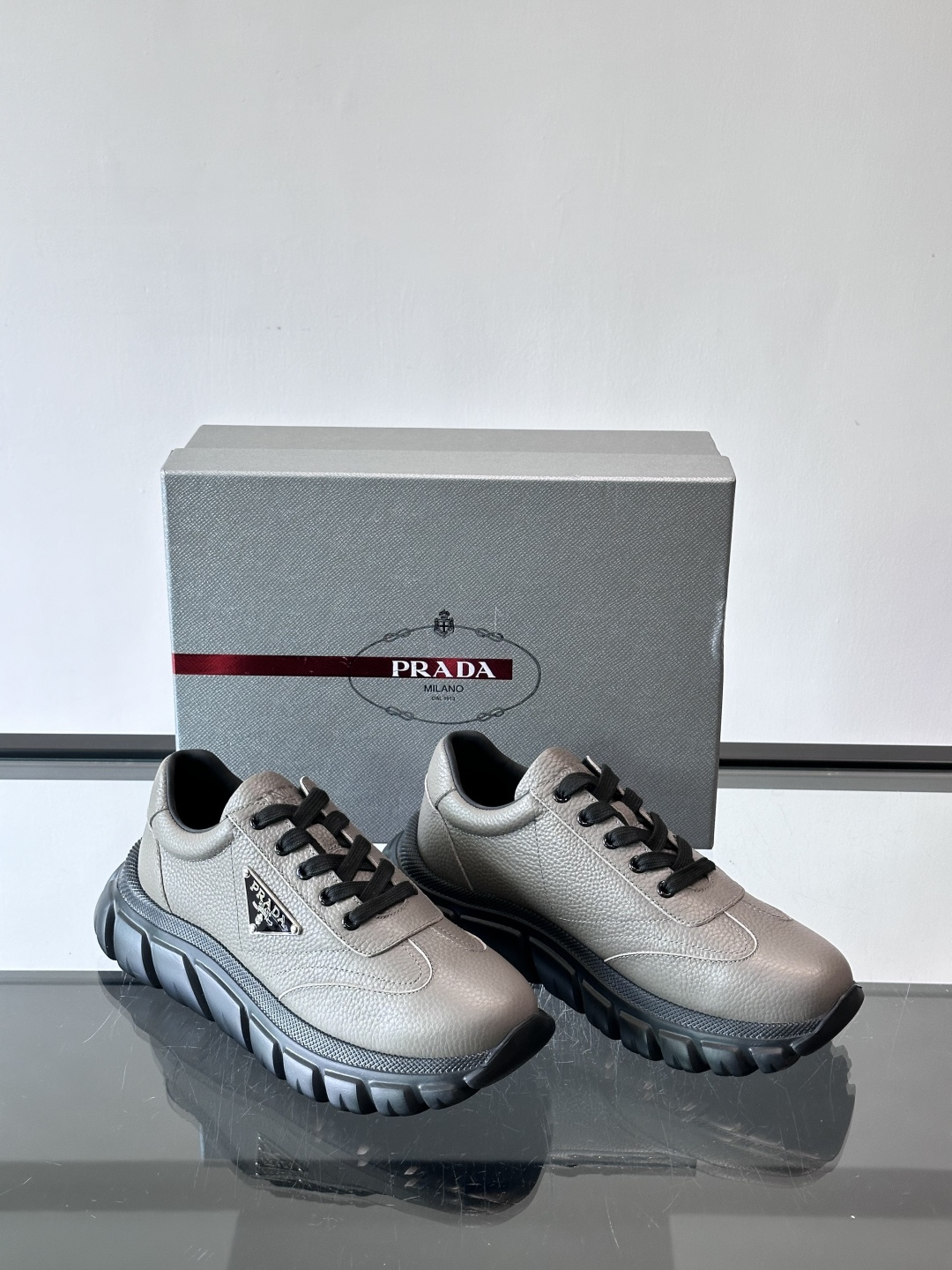 Prada男士休闲运动鞋，采用优质牛皮，鞋面柔软细腻，搭配经典三角金属Logo，品牌辨识度超高✨。厚底设