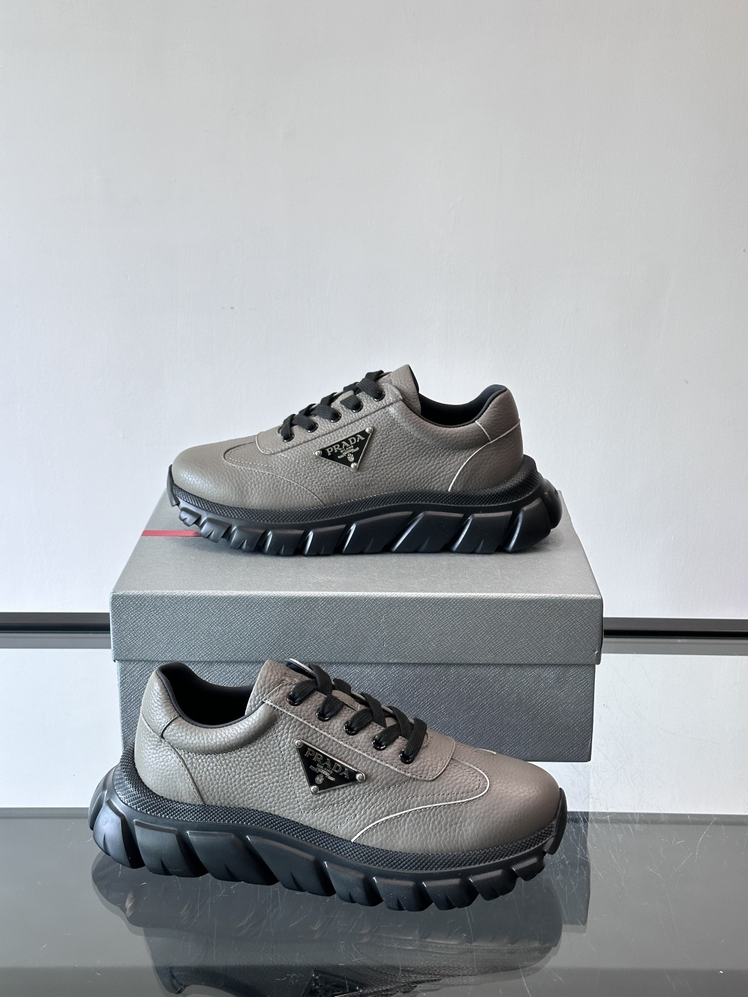 Prada男士休闲运动鞋，采用优质牛皮，鞋面柔软细腻，搭配经典三角金属Logo，品牌辨识度超高✨。厚底设
