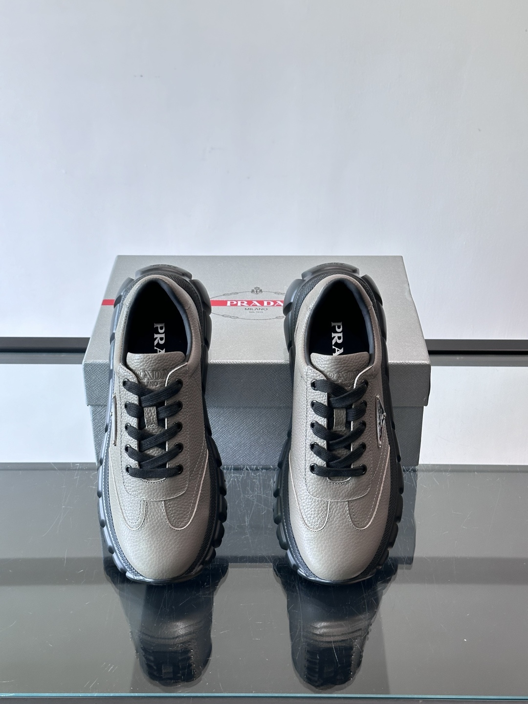 Prada男士休闲运动鞋，采用优质牛皮，鞋面柔软细腻，搭配经典三角金属Logo，品牌辨识度超高✨。厚底设