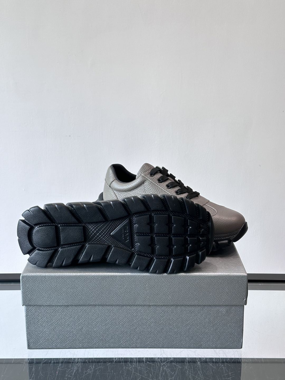 Prada男士休闲运动鞋，采用优质牛皮，鞋面柔软细腻，搭配经典三角金属Logo，品牌辨识度超高✨。厚底设