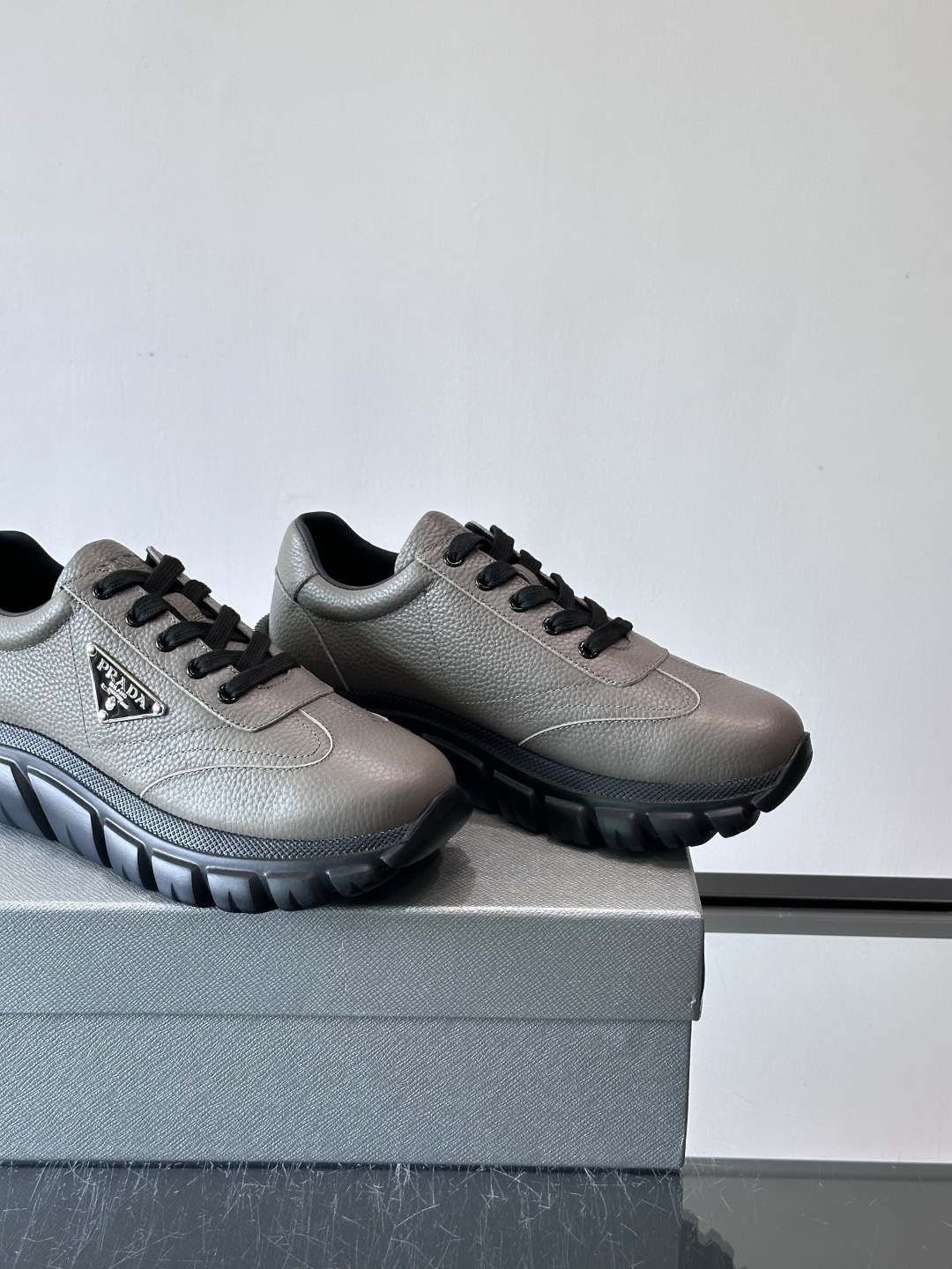 Prada男士休闲运动鞋，采用优质牛皮，鞋面柔软细腻，搭配经典三角金属Logo，品牌辨识度超高✨。厚底设
