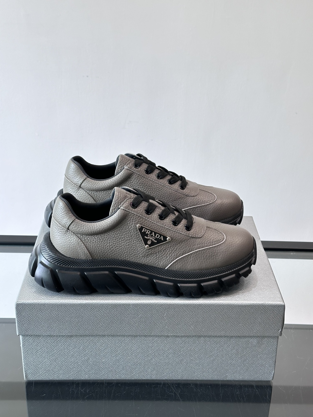 Prada男士休闲运动鞋，采用优质牛皮，鞋面柔软细腻，搭配经典三角金属Logo，品牌辨识度超高✨。厚底设