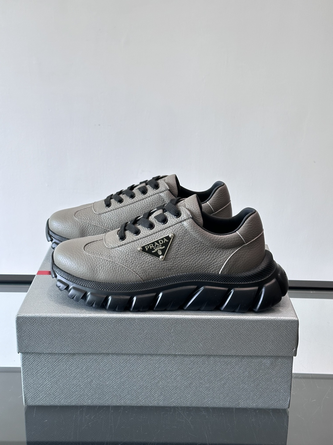 Prada男士休闲运动鞋，采用优质牛皮，鞋面柔软细腻，搭配经典三角金属Logo，品牌辨识度超高✨。厚底设