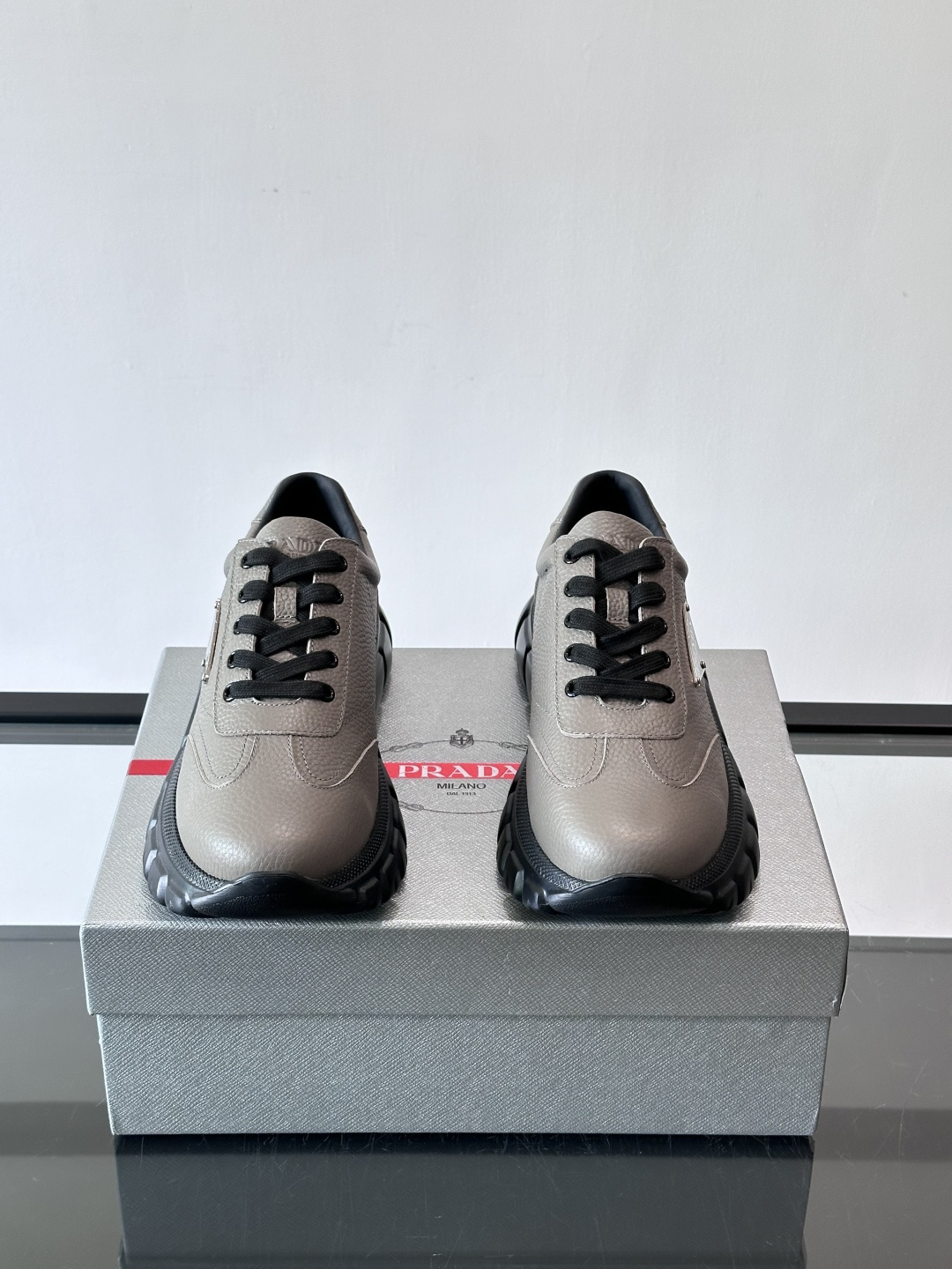 Prada男士休闲运动鞋，采用优质牛皮，鞋面柔软细腻，搭配经典三角金属Logo，品牌辨识度超高✨。厚底设