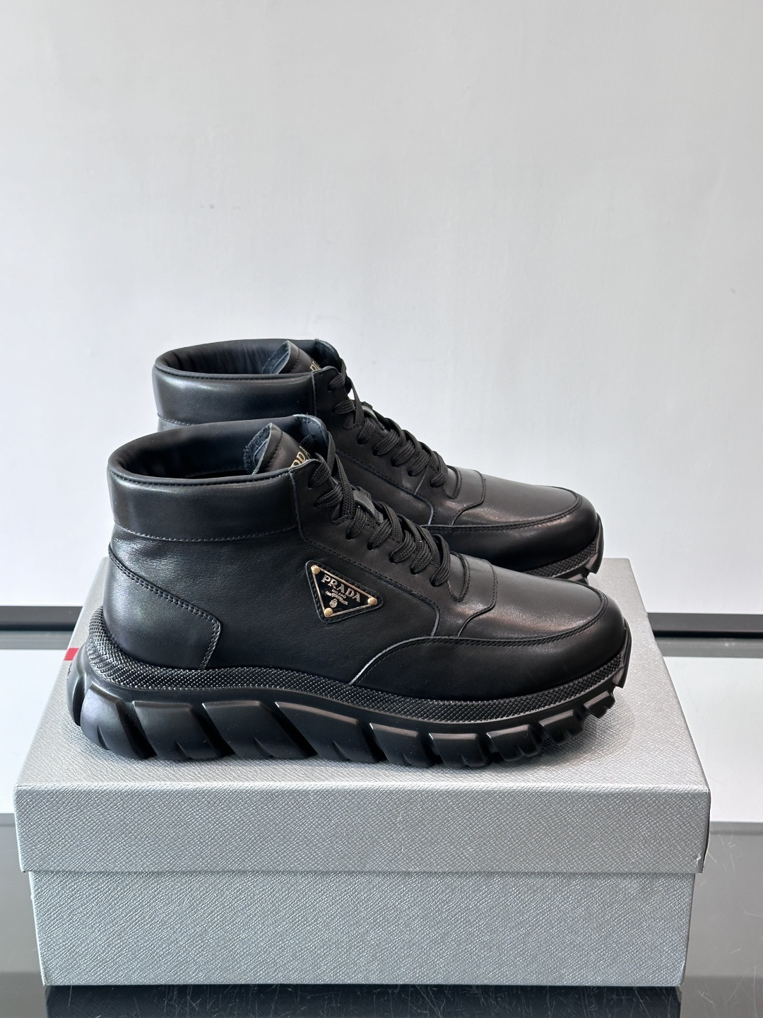 Prada三角标厚底运动鞋，高帮设计，纳帕小牛皮鞋面，柔软细腻质感满分✨。侧面三角金属珐琅徽章+鞋舌&后