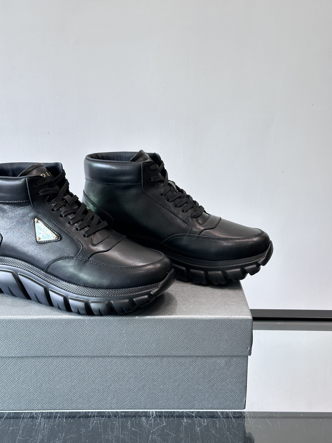 Prada三角标厚底运动鞋，高帮设计，纳帕小牛皮鞋面，柔软细腻质感满分✨。侧面三角金属珐琅徽章+鞋舌&后