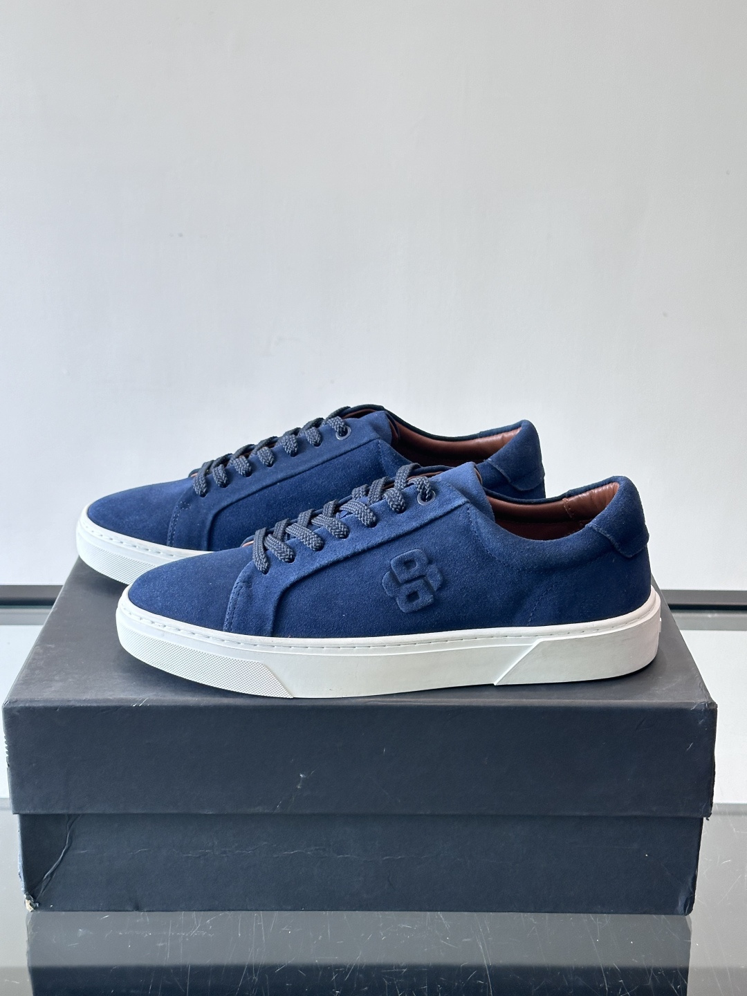 BOSS男士麂皮板鞋，选用细腻麂皮，触感柔软，低调有质感。橡胶鞋底耐磨防滑，日常通勤或休闲都很OK！鞋侧