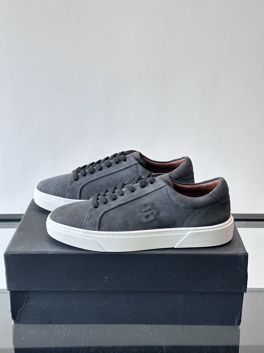 BOSS男士麂皮板鞋，选用细腻麂皮，触感柔软，低调有质感。橡胶鞋底耐磨防滑，日常通勤或休闲都很OK！鞋侧