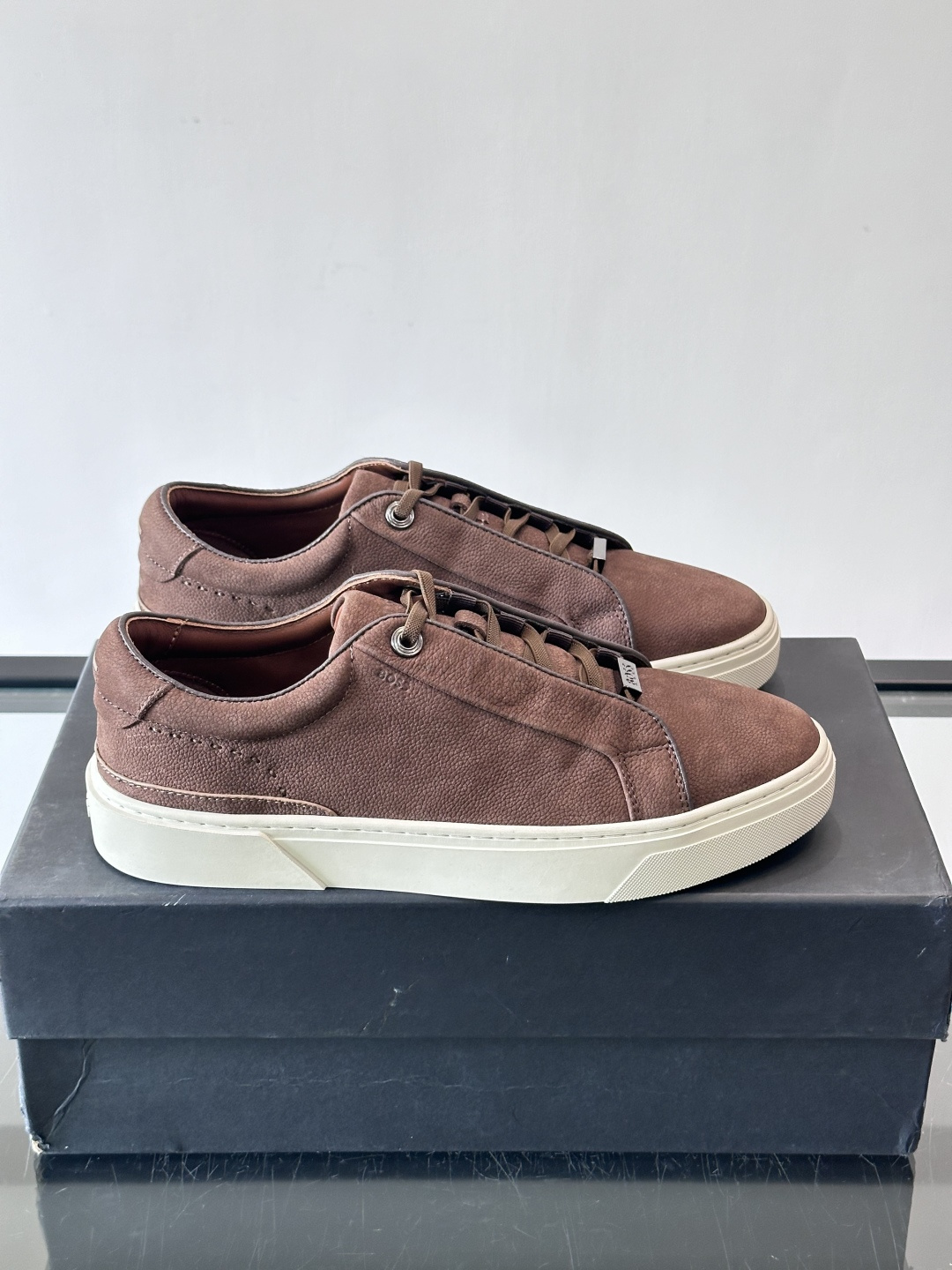 BOSS男士麂皮板鞋，选用细腻麂皮，触感柔软，低调有质感。橡胶鞋底耐磨防滑，日常通勤或休闲都很OK！鞋侧