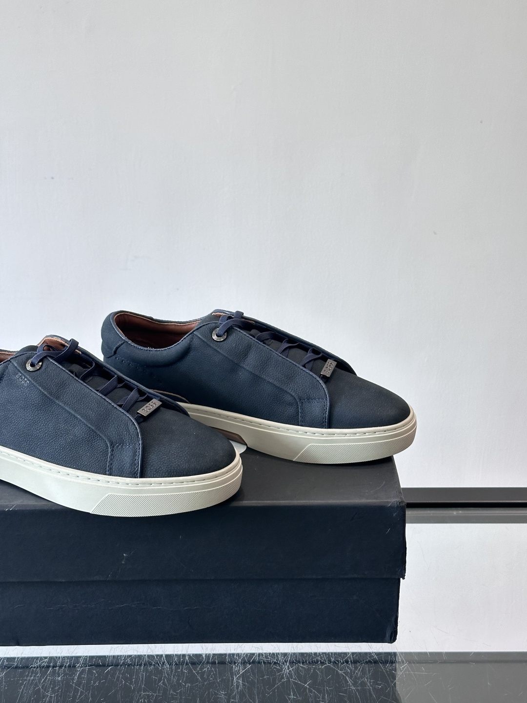 BOSS男士麂皮板鞋，选用细腻麂皮，触感柔软，低调有质感。橡胶鞋底耐磨防滑，日常通勤或休闲都很OK！鞋侧