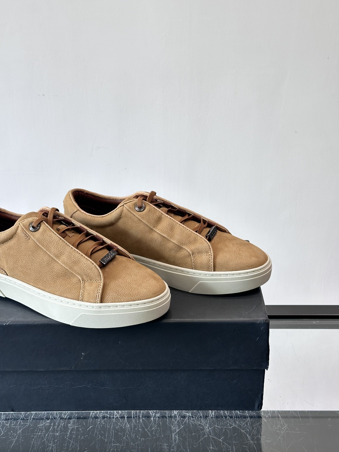 BOSS男士麂皮板鞋，选用细腻麂皮，触感柔软，低调有质感。橡胶鞋底耐磨防滑，日常通勤或休闲都很OK！鞋侧