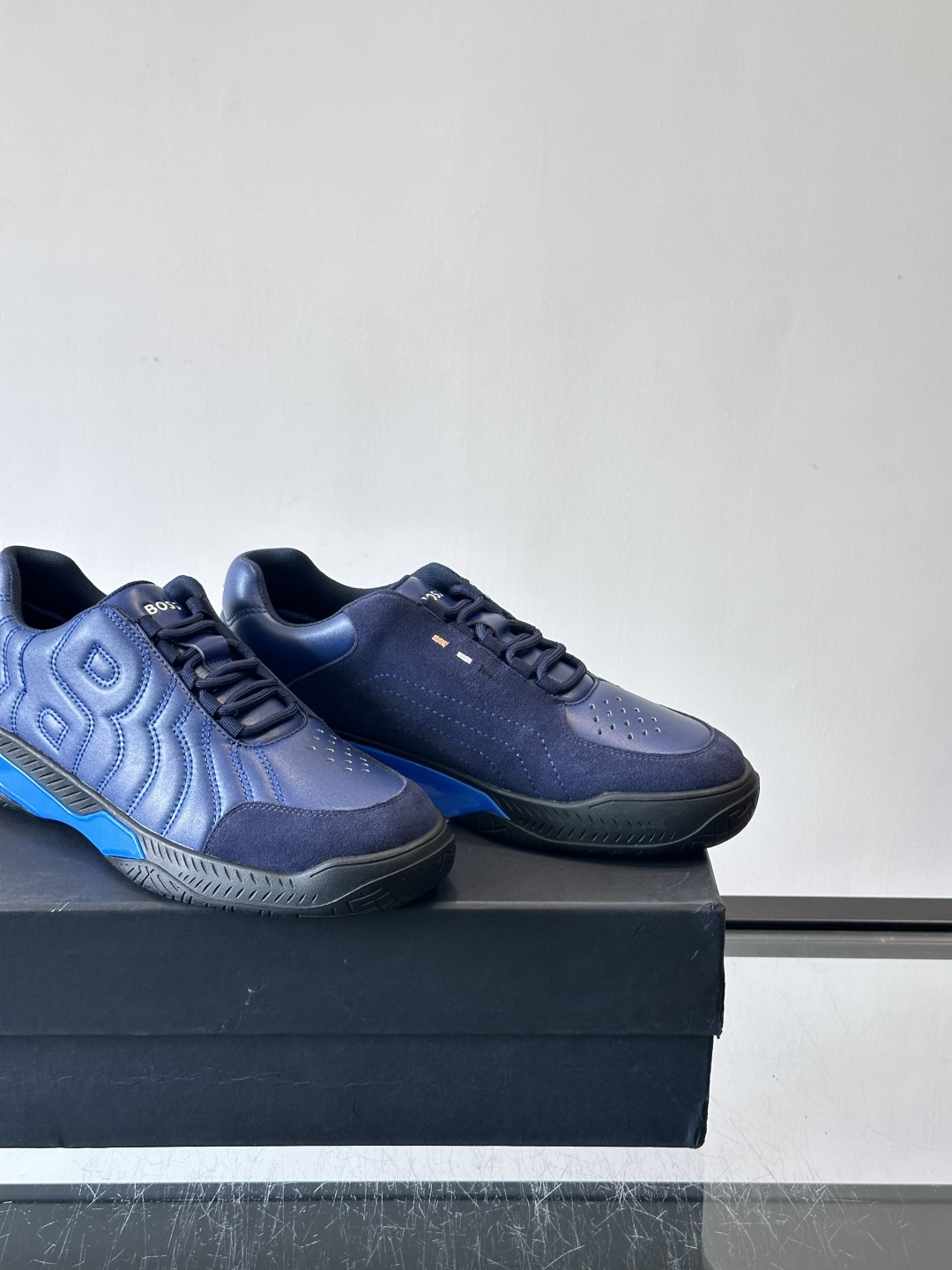 Boss Courtstride系列休闲鞋，灵感来自网球鞋，鞋面采用牛皮+绒面革拼接，绗缝工艺+双B标志