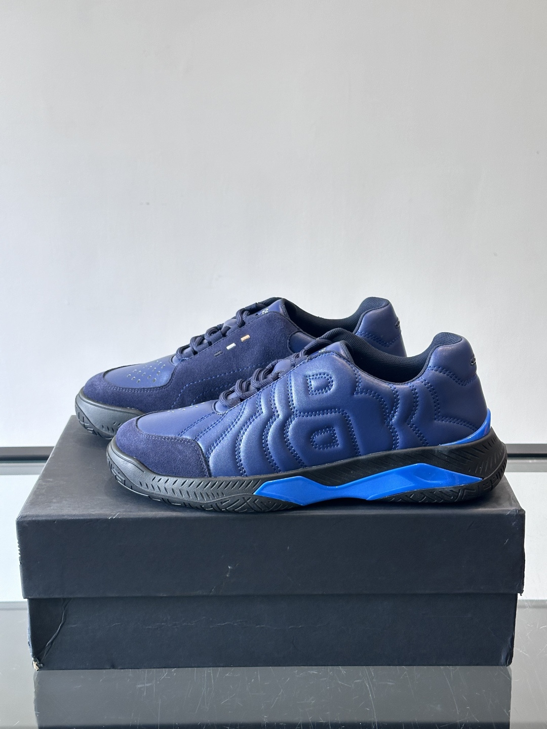 Boss Courtstride系列休闲鞋，灵感来自网球鞋，鞋面采用牛皮+绒面革拼接，绗缝工艺+双B标志