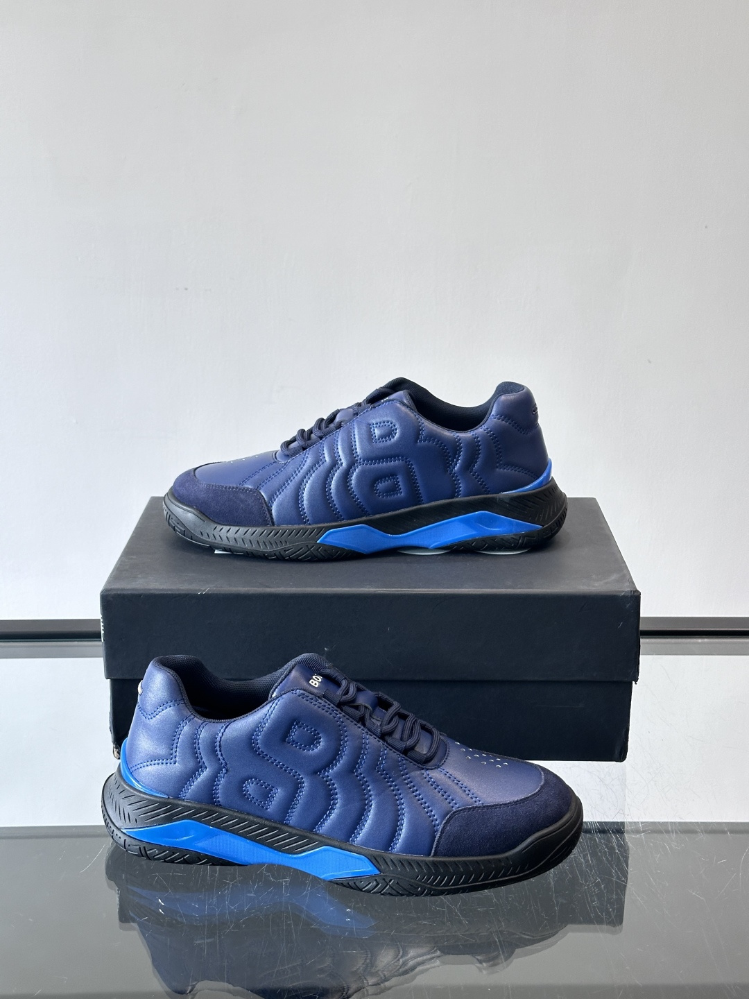 Boss Courtstride系列休闲鞋，灵感来自网球鞋，鞋面采用牛皮+绒面革拼接，绗缝工艺+双B标志