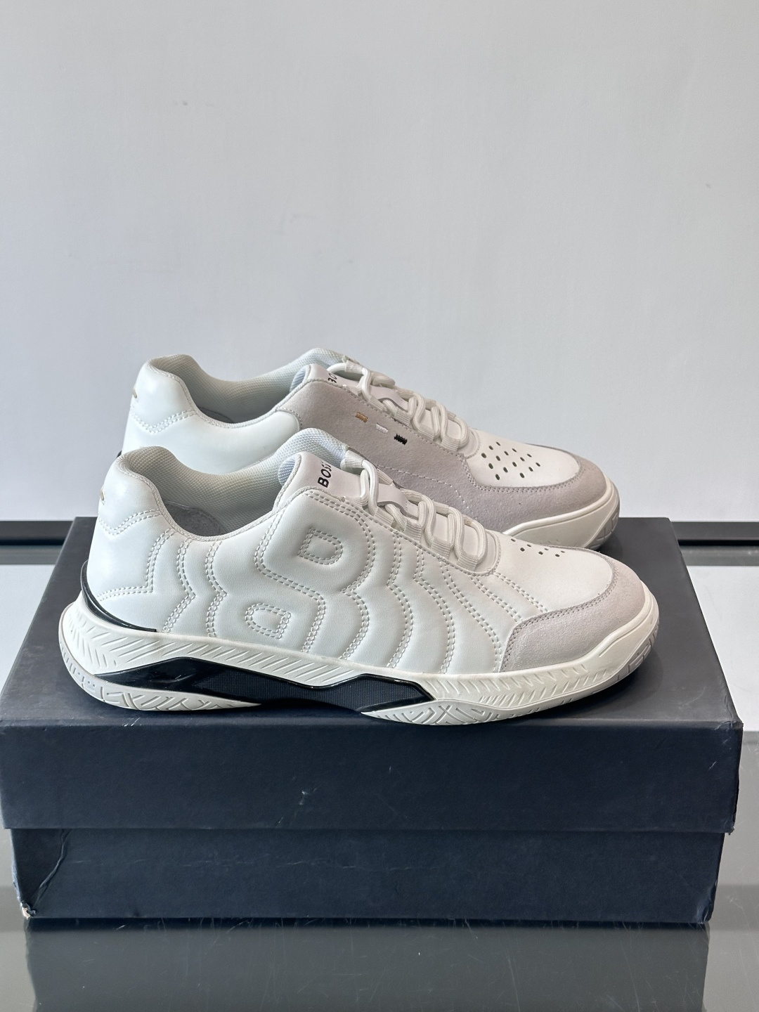 Boss Courtstride系列休闲鞋，灵感来自网球鞋，鞋面采用牛皮+绒面革拼接，绗缝工艺+双B标志