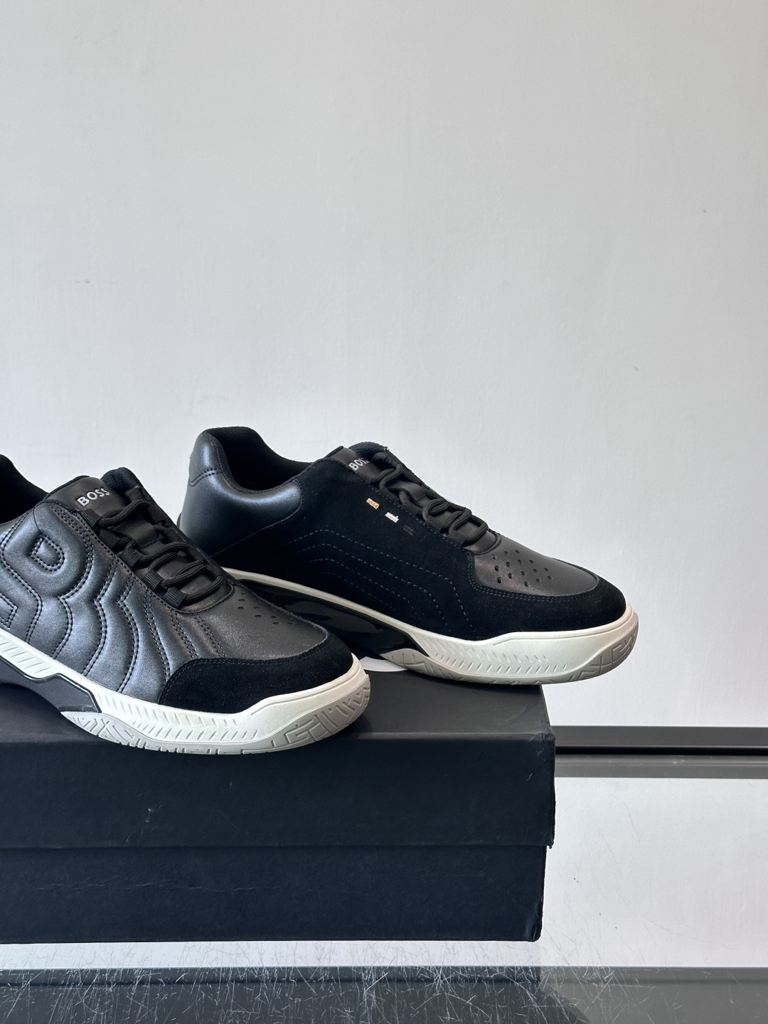 Boss Courtstride系列休闲鞋，灵感来自网球鞋，鞋面采用牛皮+绒面革拼接，绗缝工艺+双B标志