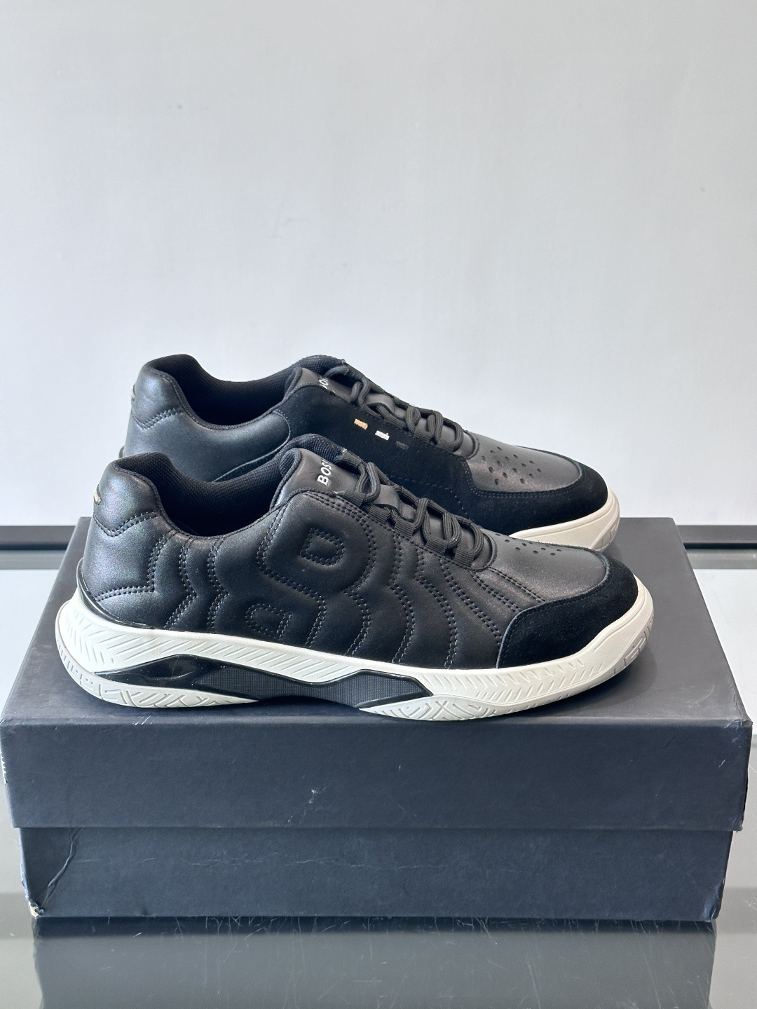 Boss Courtstride系列休闲鞋，灵感来自网球鞋，鞋面采用牛皮+绒面革拼接，绗缝工艺+双B标志